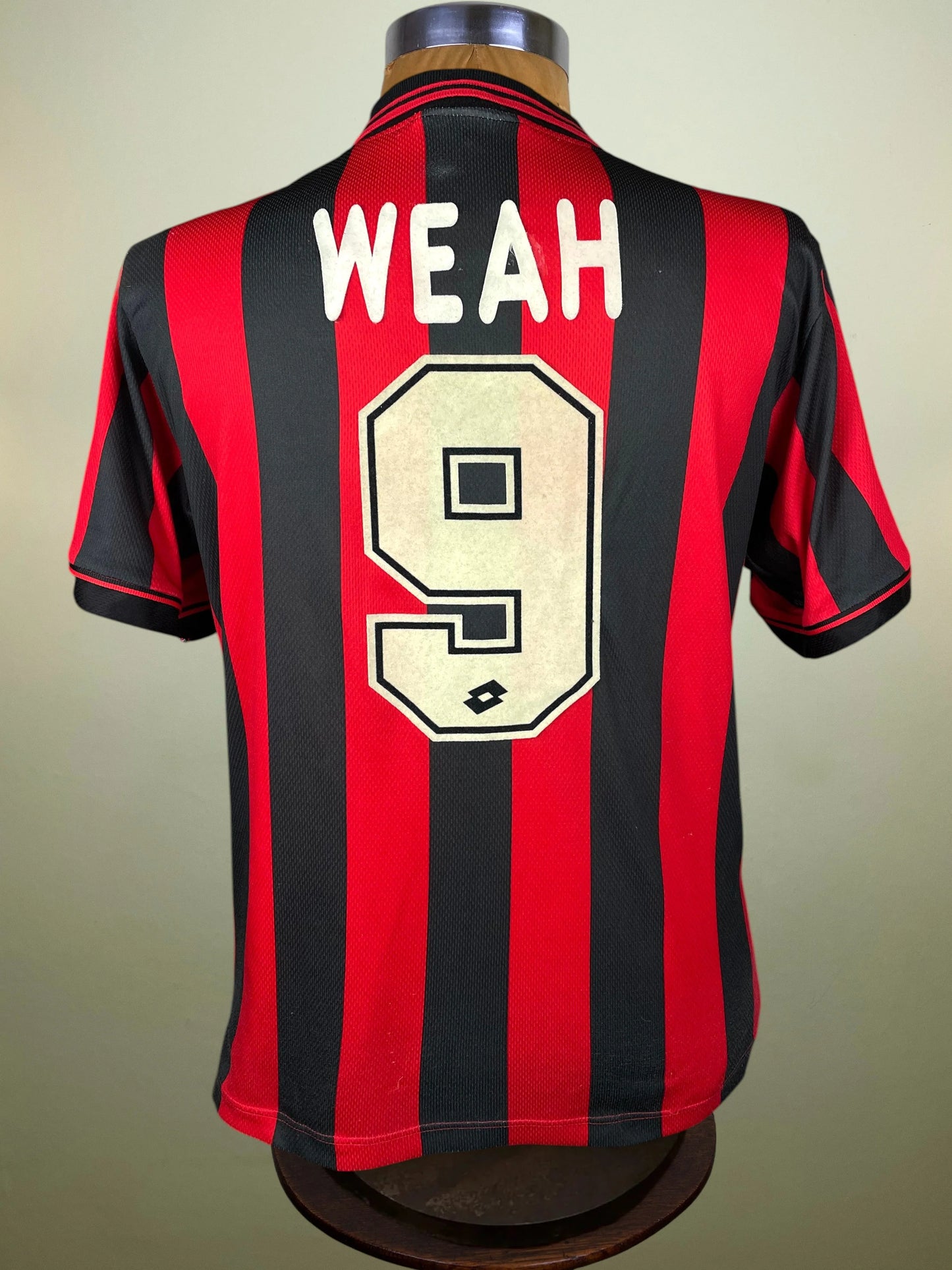 A vintage AC Milan home jersey with red and black vertical stripes