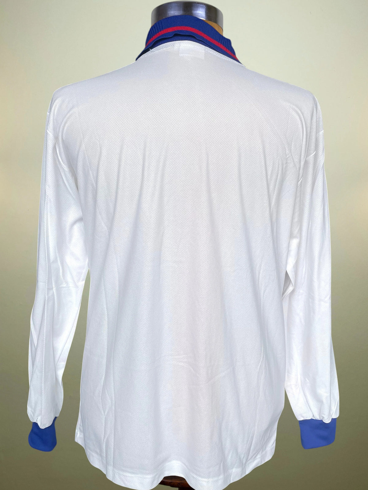  displayed on a wooden mannequin torso. The jersey is white with bold vertical red and blue stripes down the center