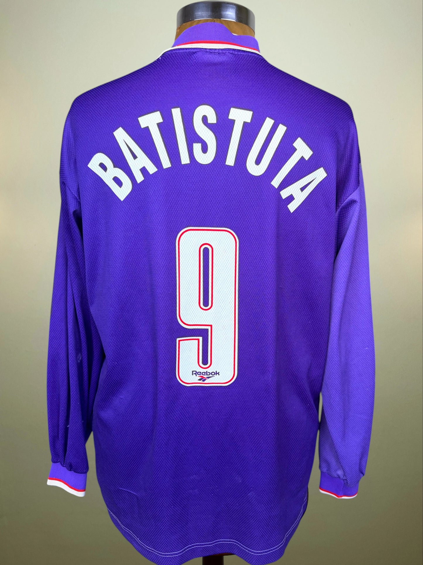 A purple long-sleeve soccer jersey displayed on a mannequin