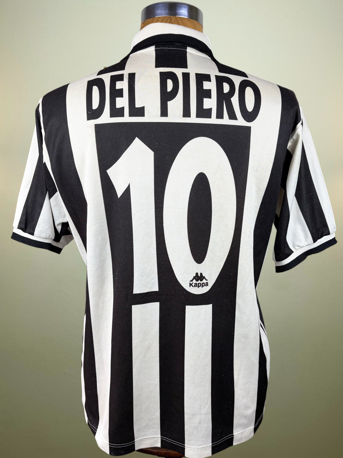 Back view of a black and white striped Juventus football jersey on a mannequin