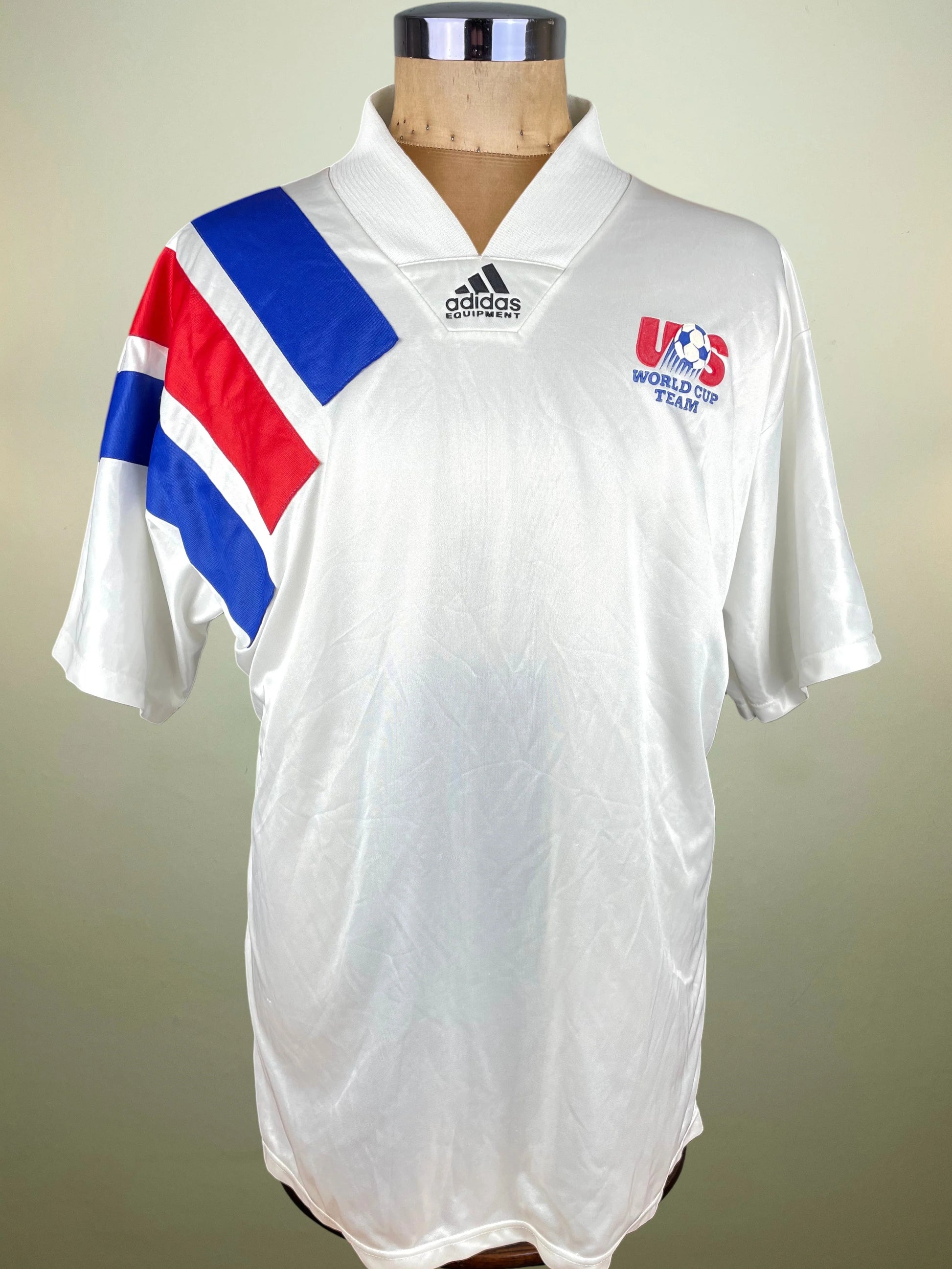 A white Adidas soccer jersey displayed on a mannequin torso