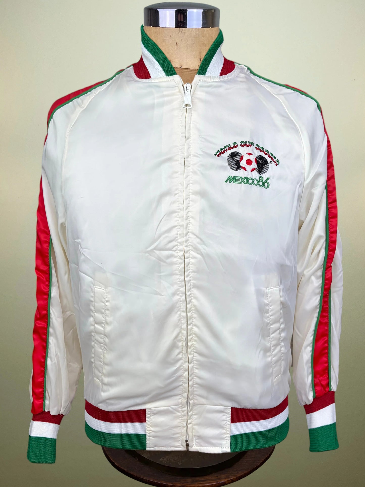 A white satin bomber jacket with red and green stripes on the sleeves
