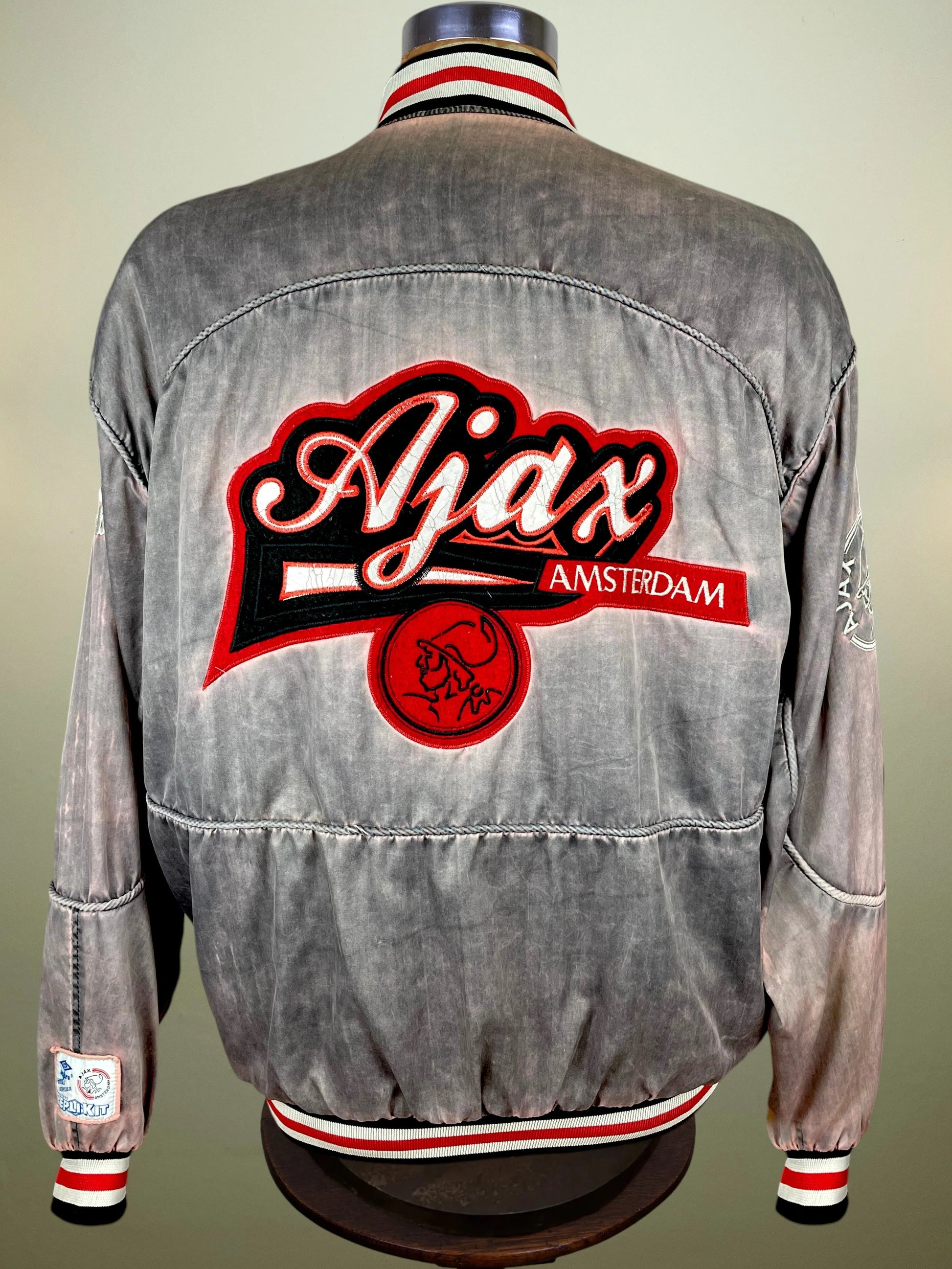 A gray acid-wash denim jacket shown from the back on a mannequin