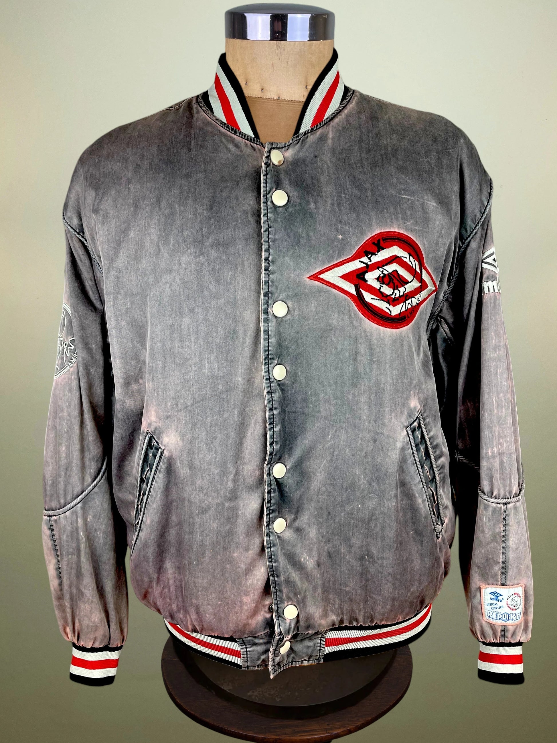  featuring a large red and black 'Ajax Amsterdam' patch on the back with red and white striped ribbed collar