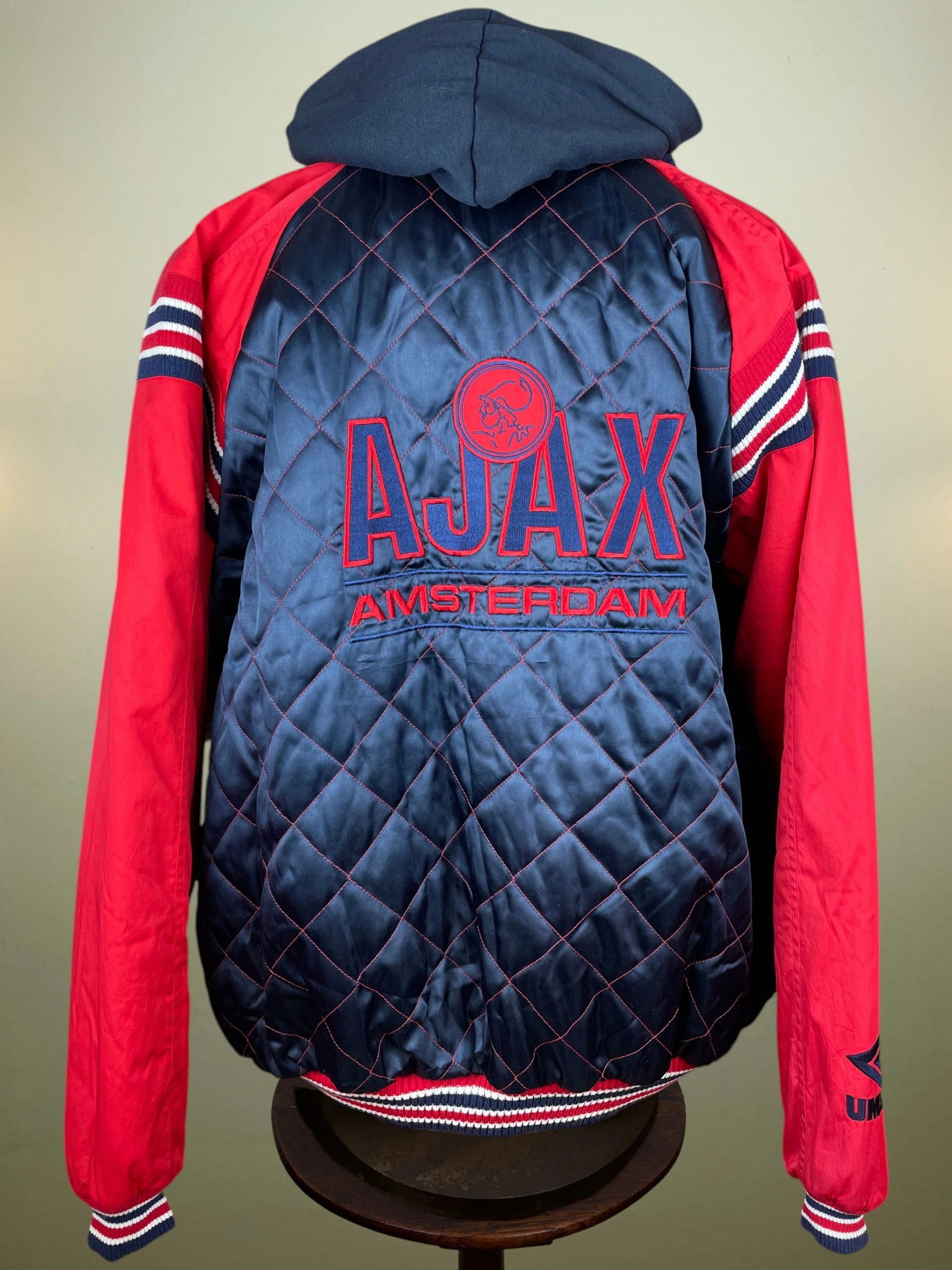 A red and navy blue Ajax Amsterdam jacket with a quilted navy back panel