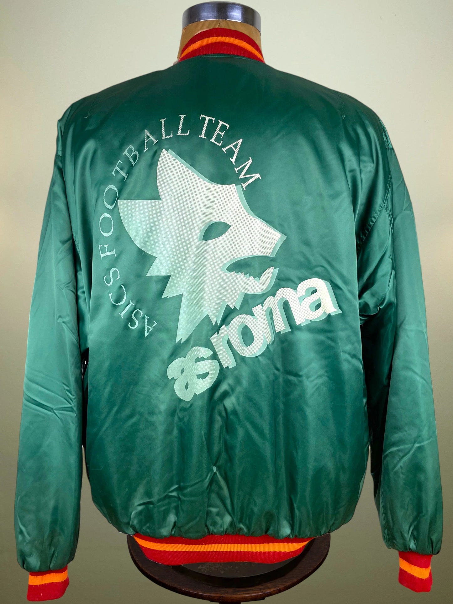 Green satin bomber jacket shown from the back on a mannequin