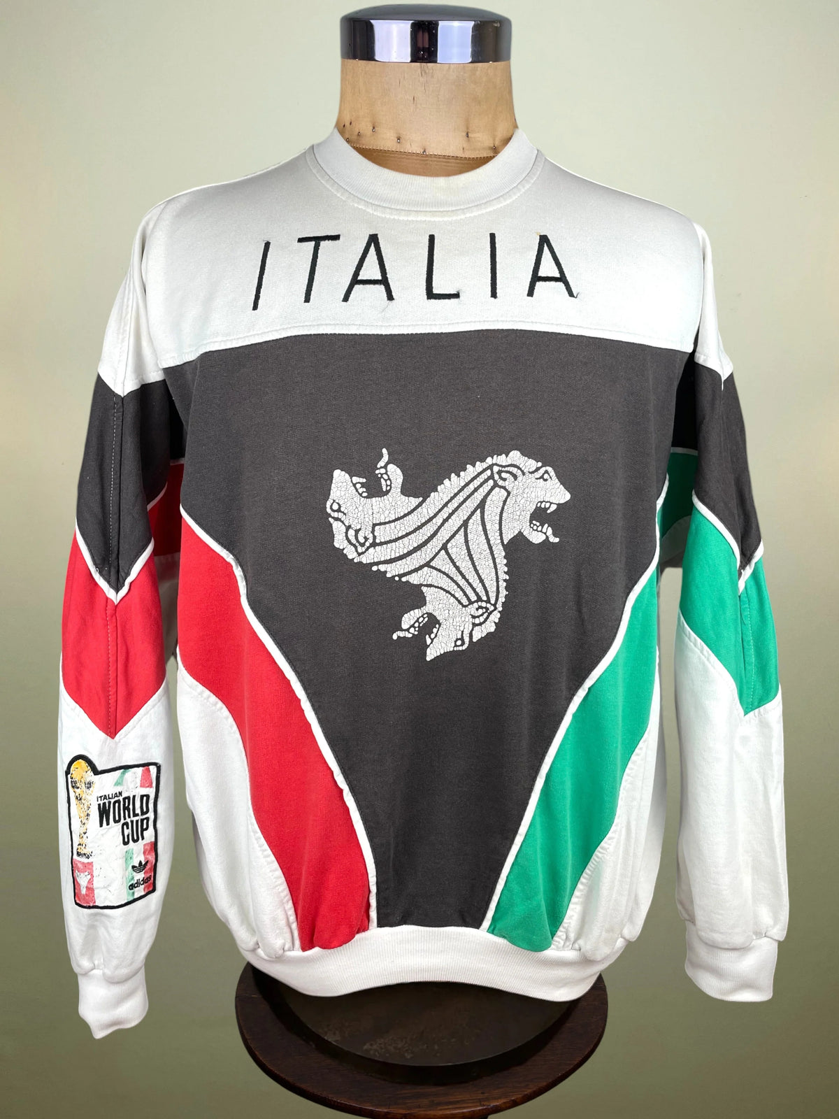 A long-sleeve crewneck sweatshirt displayed on a mannequin torso. The sweatshirt features a white